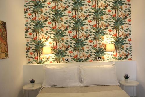 una camera da letto con una parete decorata con carta da parati a palma di Locanda Dell'Arte a Napoli