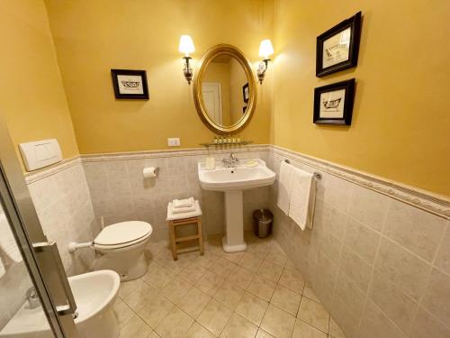 a bathroom with a sink and a toilet and a mirror at La Bohème in Lucca