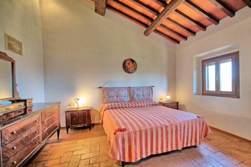 a bedroom with a bed and a dresser and a mirror at Casale Giotto by PosarelliVillas in Vicchio