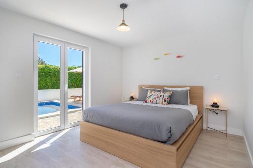 a bedroom with a bed and a large window at Villa do Pinhal in Olhos de Água