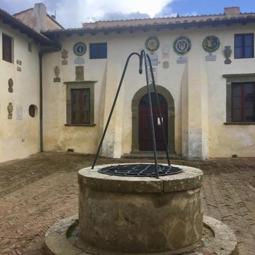 a building with a fountain in front of it at Villa Carlotta con piscina in Lari