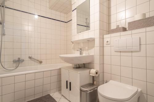 a white bathroom with a sink and a toilet at Arbeitsplatz, Balkon, Tiefgarage nähe neue Messe in Leipzig