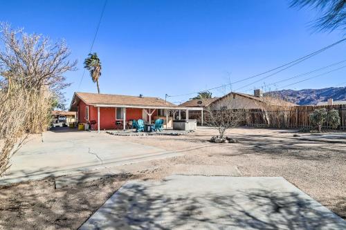 a house with a palm tree in the yard at Cali Desert Oasis with Hot Tub and Mtn Views! in Twentynine Palms
