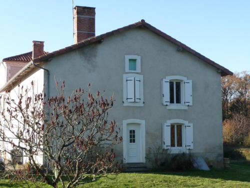 a white house with two windows and a tree at Gîte des Forces - Limousin - Haute Vienne in Saint-Bazile