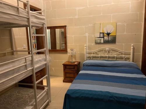 a bedroom with two bunk beds and a lamp at Qronfli Holiday Apartments With Swimming Pool in San Lawrenz