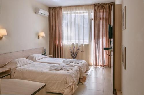 ein Hotelzimmer mit 2 Betten und einem Fenster in der Unterkunft Александра in Sweti Wlas