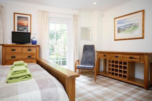 Schlafzimmer mit einem Bett, einem Schreibtisch und einem Stuhl in der Unterkunft Edinburgh Mews Apartment in Edinburgh