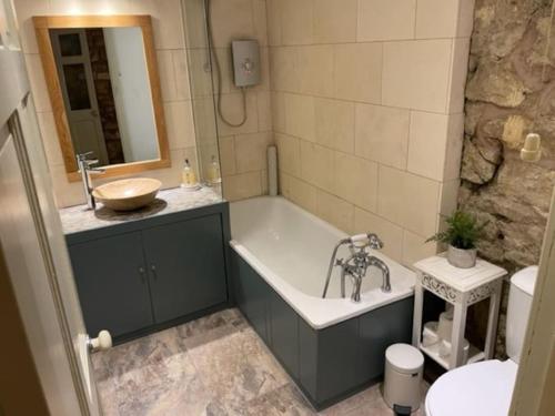 a bathroom with a bath tub and a sink at Belvedere Villas in Bath