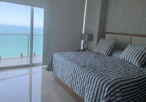 a bedroom with a bed with a view of the ocean at Camino al mar "Departamento en playa" in Mazatlán