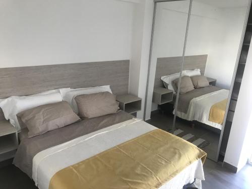 1 dormitorio con 2 camas y espejo en Espacio Chacabuco en Comodoro Rivadavia