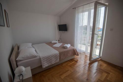 a bedroom with a bed and a large window at Apartment Miro in Dolac