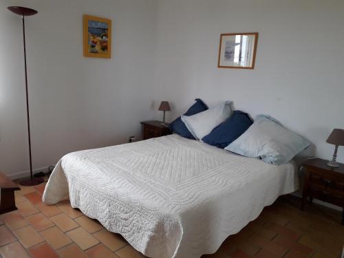 une chambre avec un lit blanc avec des oreillers bleus dans l'établissement Farniente, à Bandol