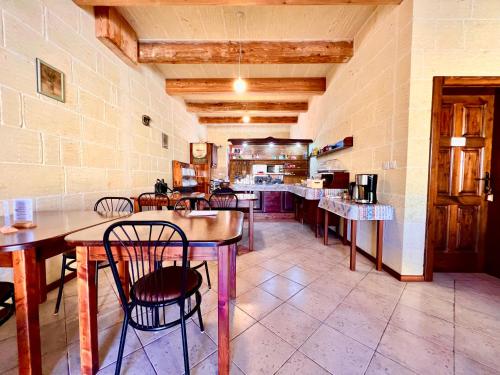 a restaurant with tables and chairs in a room at Grotto's Paradise B&B in Għarb