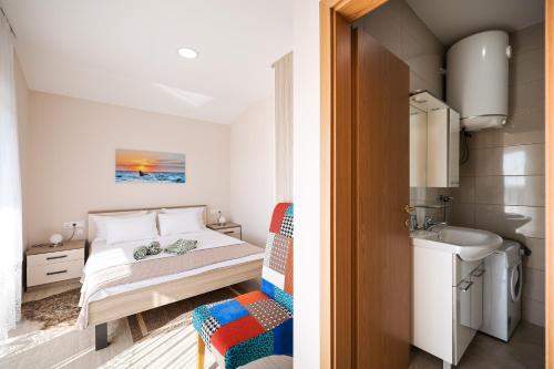 a small bedroom with a bed and a sink at Apartments Anka with Seaview in Vrsi