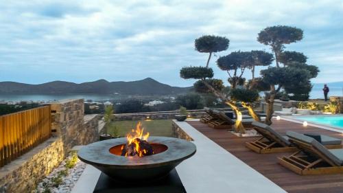 a fire pit on a patio next to a pool at The Olive Tree Villa Elounda in Elounda