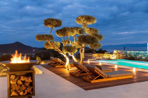 a resort with a fire pit and trees on the roof at The Olive Tree Villa Elounda in Elounda