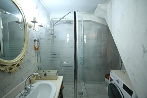 a bathroom with a shower and a sink and a mirror at Kleopatra's House in Karavostamo