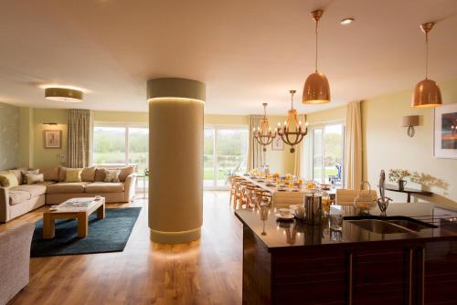 a kitchen and living room with a large column at Herons House Sleeps 12, heated Pool, hot tub, sauna, games room 5 Star! in Saint Columb Major