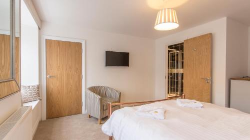Schlafzimmer mit einem weißen Bett und einem TV in der Unterkunft Tamar View by Pureserviced in Plymouth