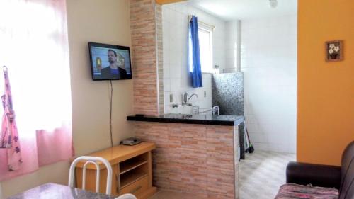 een woonkamer met een stenen open haard en een wastafel bij Apartamento na quadra do mar da Praia do Morro! in Guarapari