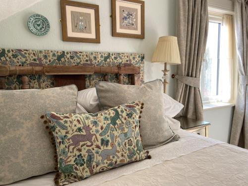 sypialnia z łóżkiem z poduszkami i oknem w obiekcie The Artist Residence Dublin w mieście Sutton