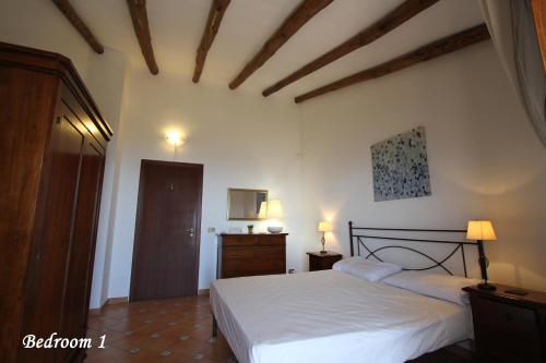 een slaapkamer met een wit bed en een houten plafond bij Villa Etna Mare - Pool villa in peaceful location with breathtaking views of the sea, Mt Etna & Taormina - in Taormina