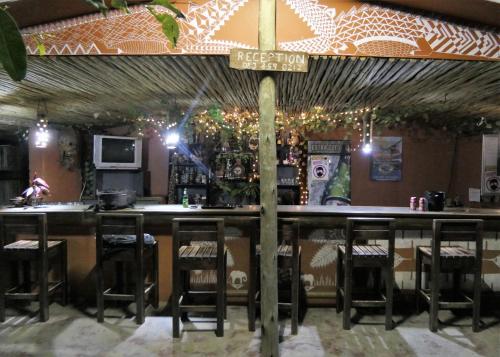 a bar with stools and a sign in a restaurant at Hazyview Adventure Backpackers in Hazyview