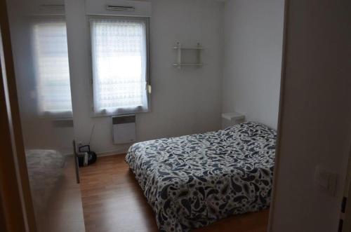 um pequeno quarto com uma cama e uma janela em BIARRITZ T3 CENTRE 4/6 PERS,TERRASSE et PARKING em Biarritz