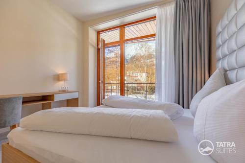 two beds in a bedroom with a window at TATRA SUITES Senior Lux Apartment C413 in Smokovce