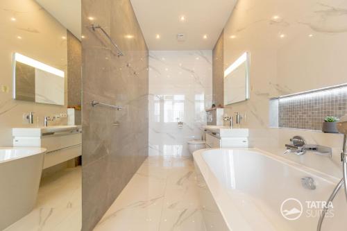 a large bathroom with a tub and a shower at TATRA SUITES Senior Lux Apartment C413 in Smokovce