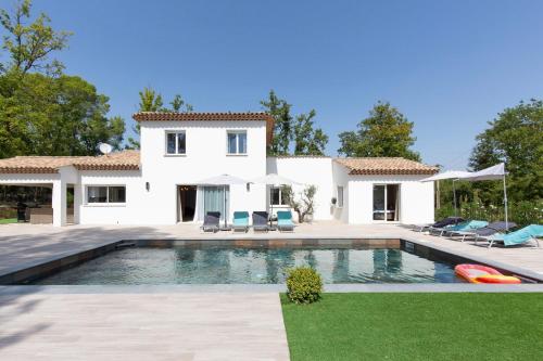 a villa with a swimming pool in front of a house at Superbe Villa Seillans LA GRANDE BASTIDE avec piscine, jardin, climatisation et salle de sport in Seillans