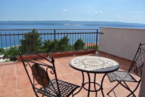 a patio with a table and chairs on a balcony at Mirabilis - Private Beach House in Lokva Rogoznica