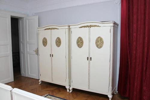 three white lockers in a room with a red curtain at Mosaico Alfetta Hostel in Timişoara