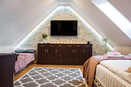 a loft bedroom with a tv on a brick wall at Apartamenty WIKTORIA morska18 in Kuźnica