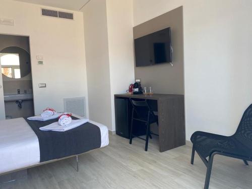 a bedroom with a bed and a desk and a chair at Brezza Marina in Porto Recanati