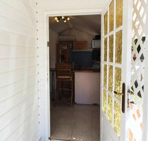 a door leading into a kitchen with a kitchenasteryasteryasteryasteryasteryasteryastery at Bungalow d'une chambre avec jardin clos et wifi a Fort de France in Fort-de-France