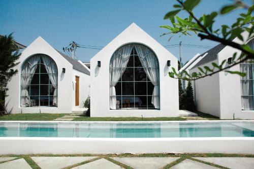 a house with a swimming pool in front of it at La Kana Boutique Villa in Kamphaeng Phet