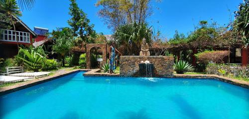 a swimming pool with a fountain in a yard at Hotel ECOLODGE LE RAVORAHA in Sainte Marie