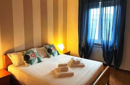 1 dormitorio con 1 cama con toallas y ventana en Apartment Station Sesto - Affitti Brevi Italia, en Sesto San Giovanni