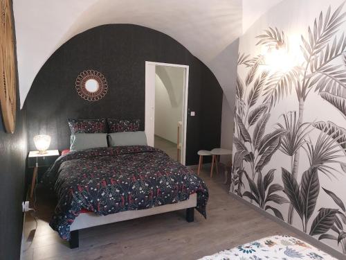 - une chambre avec un lit et un mur orné d'une fresque murale dans l'établissement L'INATTENDU Vue imprenable, lits préparés et ménage inclus, à Montaigu