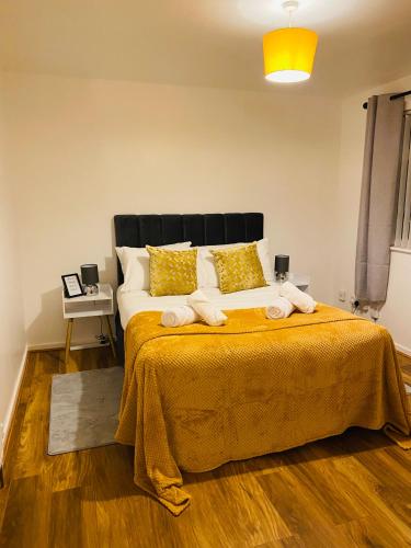 a bedroom with a large bed with a yellow blanket at Cheerful home near City Centre,Station& RaceCourse in Doncaster