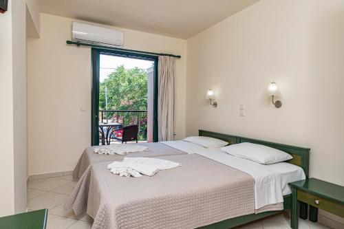 two beds in a room with a window at Gianna Apartments in Almirida