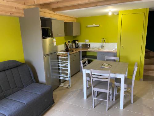 a kitchen and dining room with a table and a couch at Gîtes Aubergine et Poivron in Toulaud
