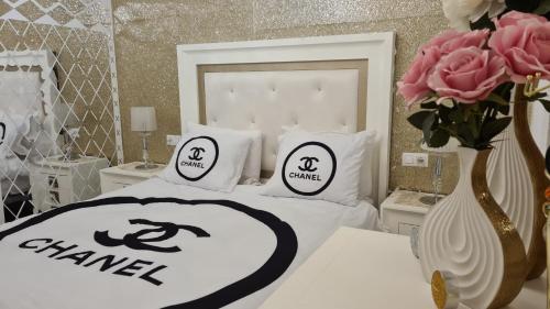 ein weißes Bett mit Kissen und eine Vase mit Blumen in der Unterkunft EL APARTAMENTO DE AMY CON VISTAS AL MAR in Mazagón