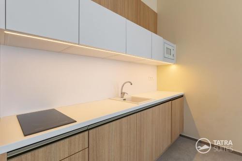 a kitchen with a sink and a counter top at TATRA SUITES Senior Lux Apartment C413 in Smokovce