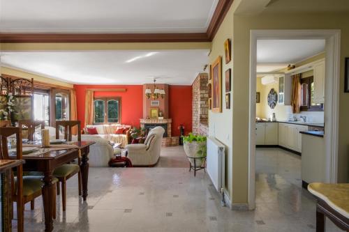 a kitchen and living room with red walls at Vivian's Residence Endless View in Svoronata
