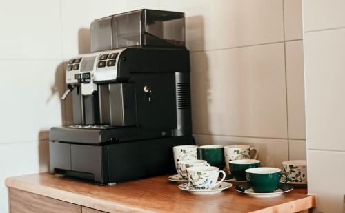 uma máquina de café sentada em cima de uma mesa com chávenas em Tarasówka u Zająca em Ząb