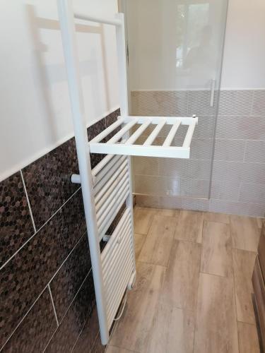 une douche à l'italienne avec une étagère blanche dans une salle de bain dans l'établissement Villa des Roses - Maison familiale, 3 chambres au calme, wifi, au Havre