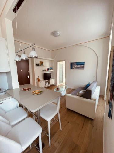 a kitchen and living room with a table and a couch at La casa di Grace in Savona
