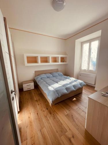 a bedroom with a bed and a wooden floor at La casa di Grace in Savona